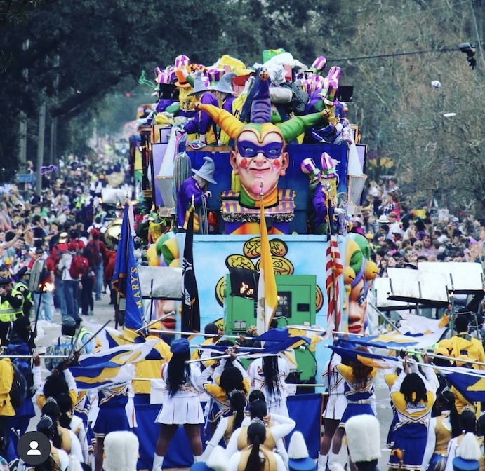 krewe a group of people standing in front of a crowd