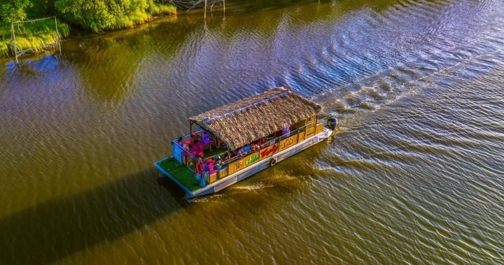 The Cheeky Tiki – Up to 25 guests! Boat Party on the Bayou Image 1 a small boat in a body of water