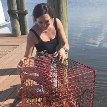 a woman sitting at a table in front of water